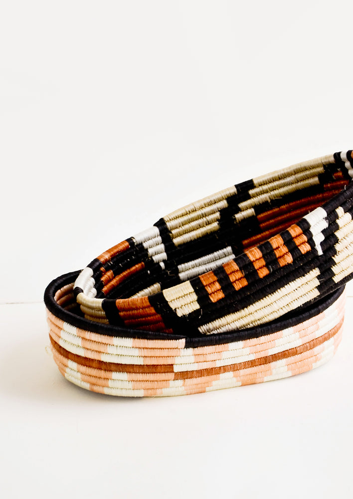 Oval shaped shallow bread baskets made from woven natural grass in geometric patterns