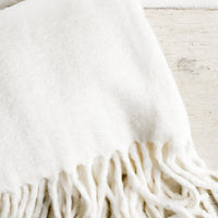 Ecru: A fuzzy ivory blanket with fringe.