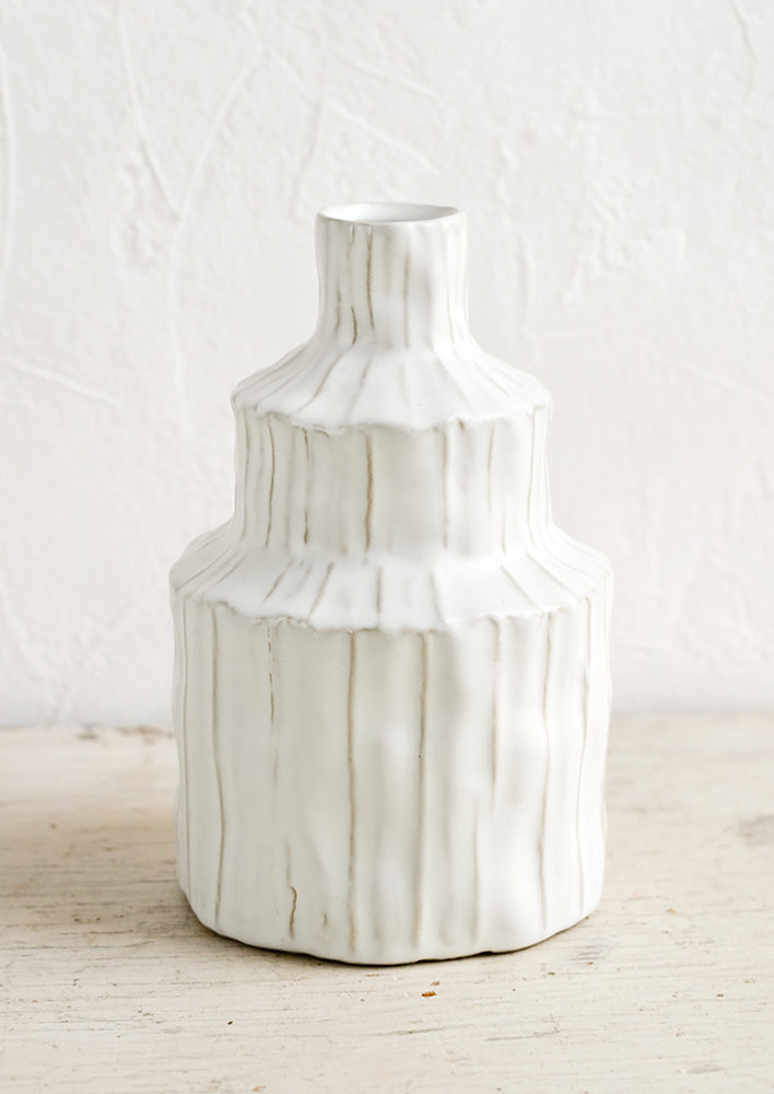 2: A textured white vase in an asymmetrical shape.