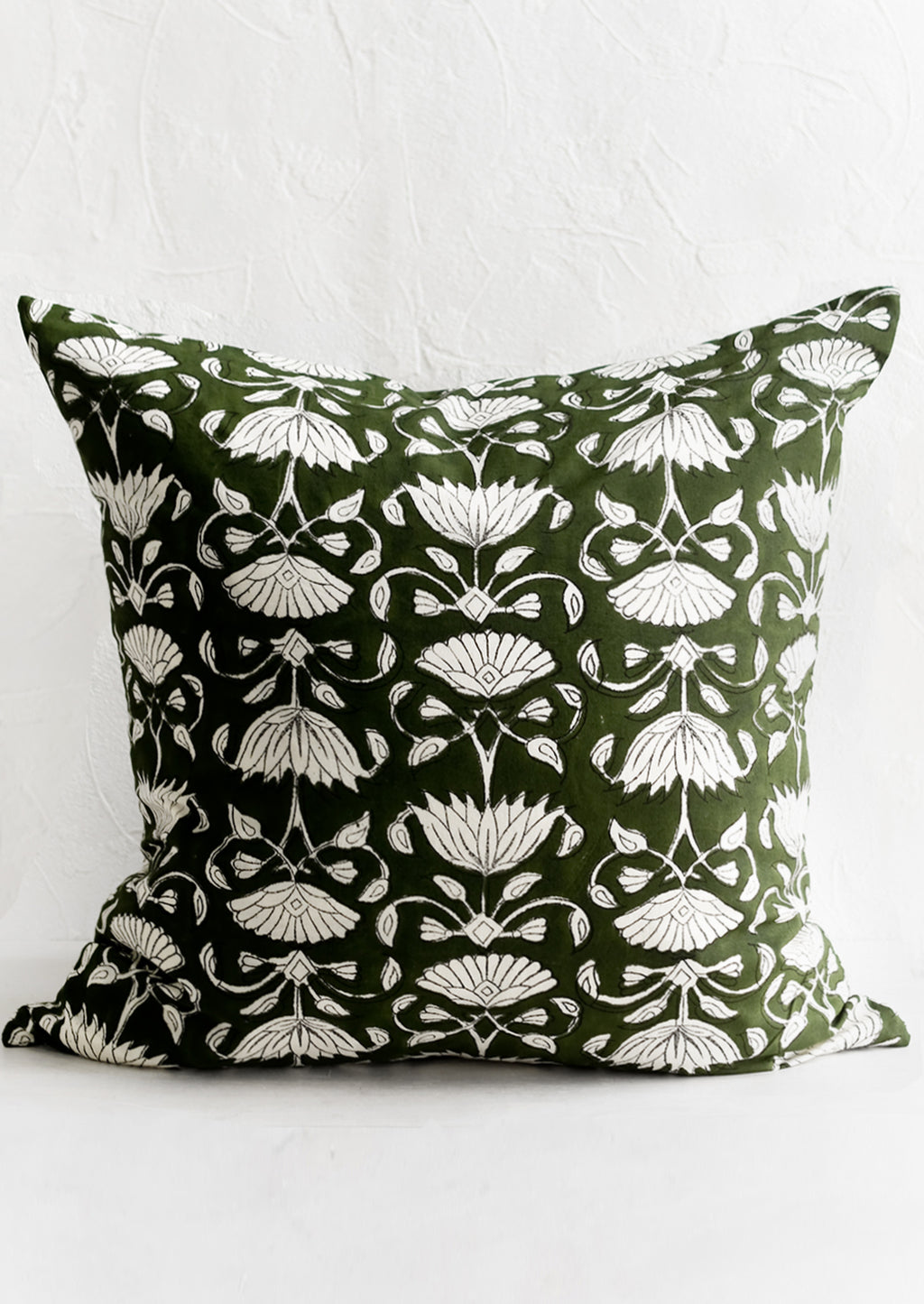 1: A block printed pillow in green and ivory floral motif.