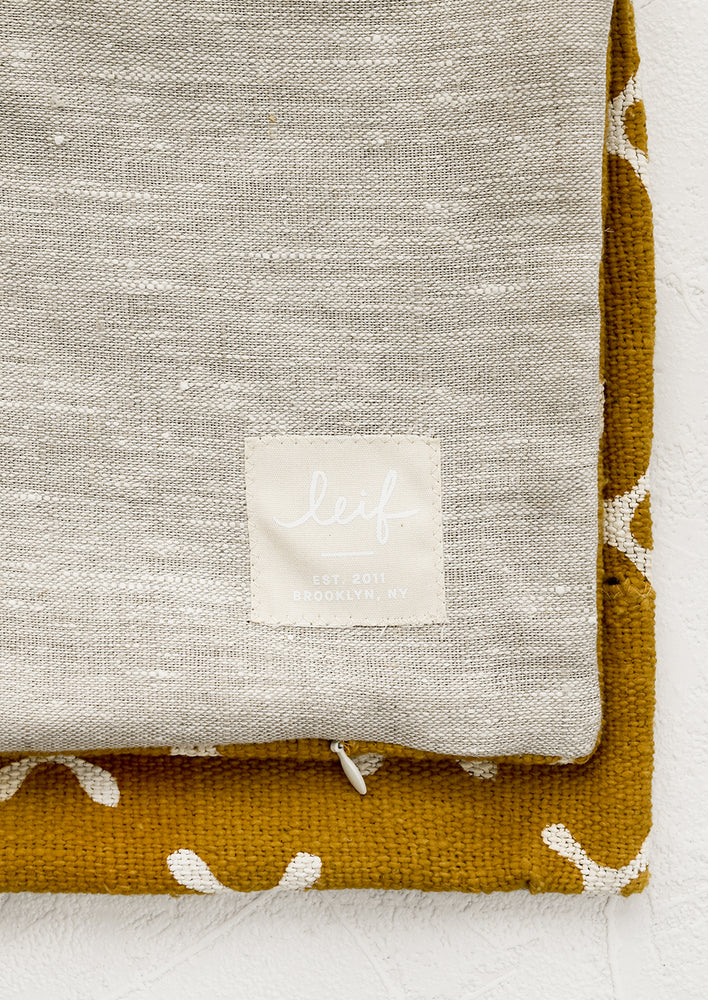 3: Natural linen pillow backing with logo patch.