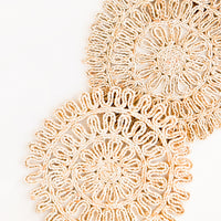 2: Set of two round placemats in natural straw in a decorative woven pattern