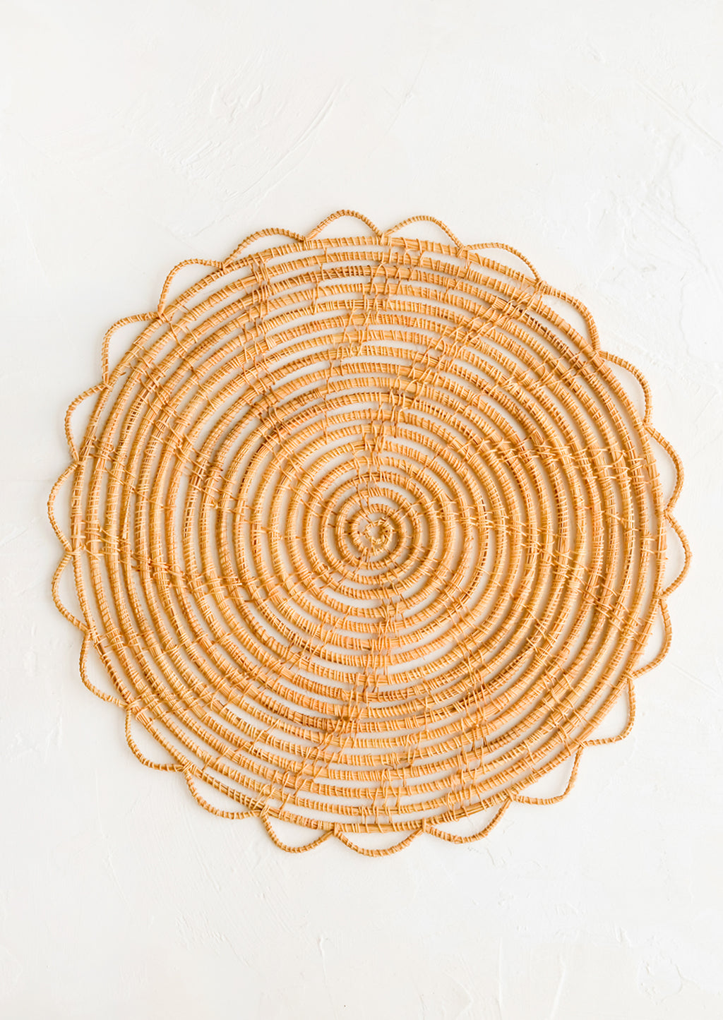 1: A round placemat with open weave scalloped edge.