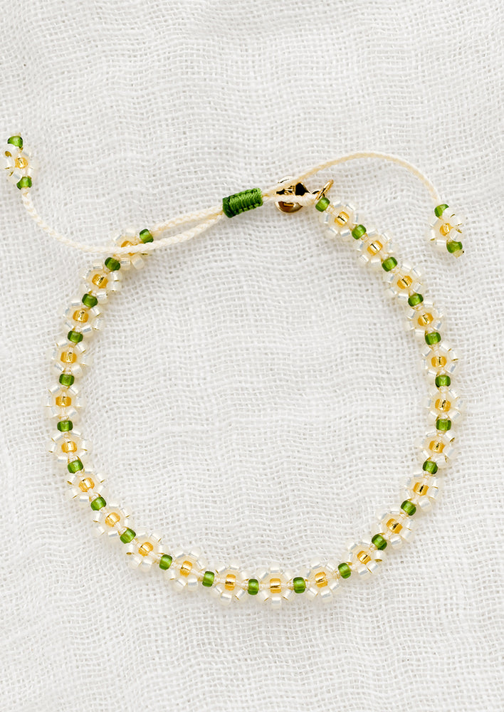 A beaded floral bracelet in white, green and yellow.