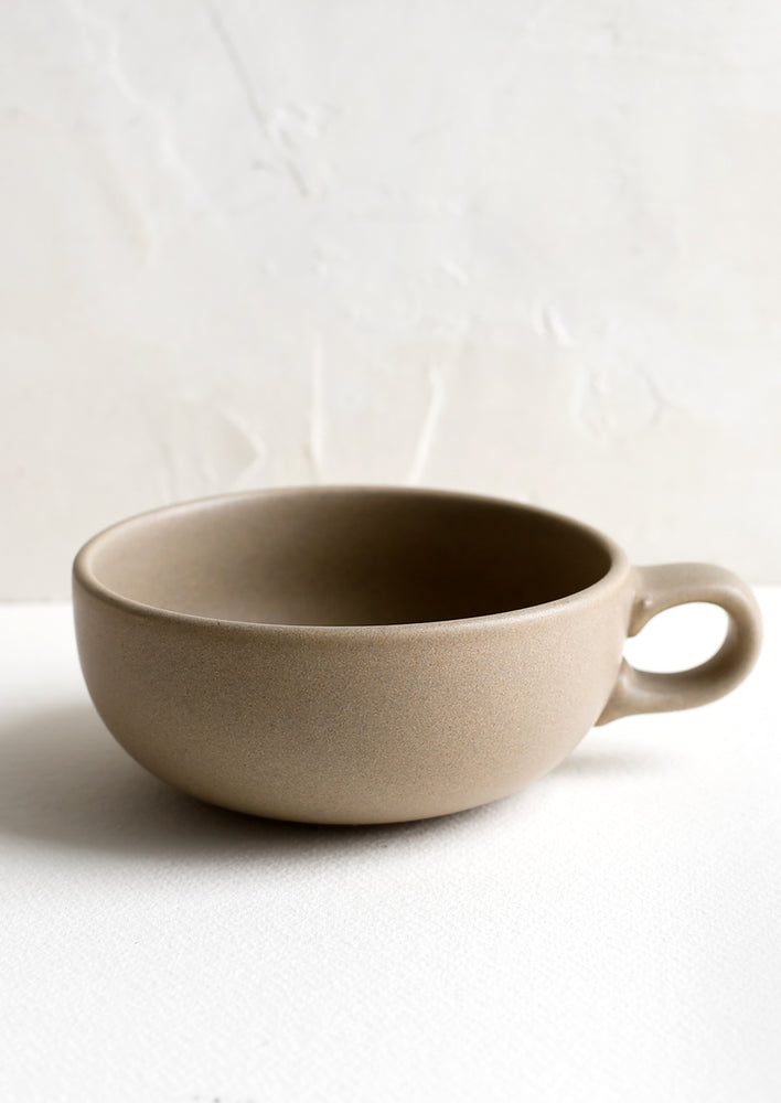 A ceramic bowl mug in sand brown.