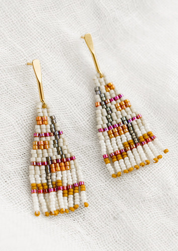 Bone Multi: A pair of beaded earrings in neutral and magenta colorway.