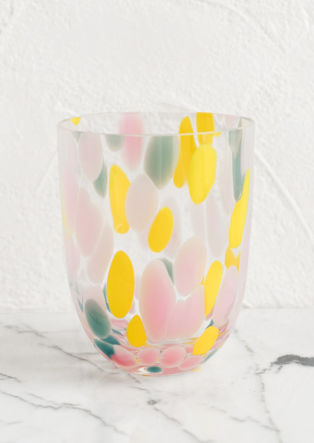 Multi / Sparse: A handmade speckled glass juice cup with teal, yellow and pink spots.
