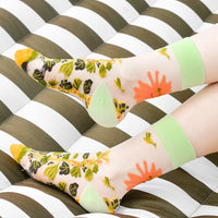 1: A person's ankles wearing sheer printed socks.