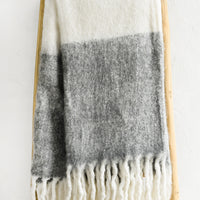 Heather Grey: A mohair throw blanket in white and heather grey with long fringe trim.