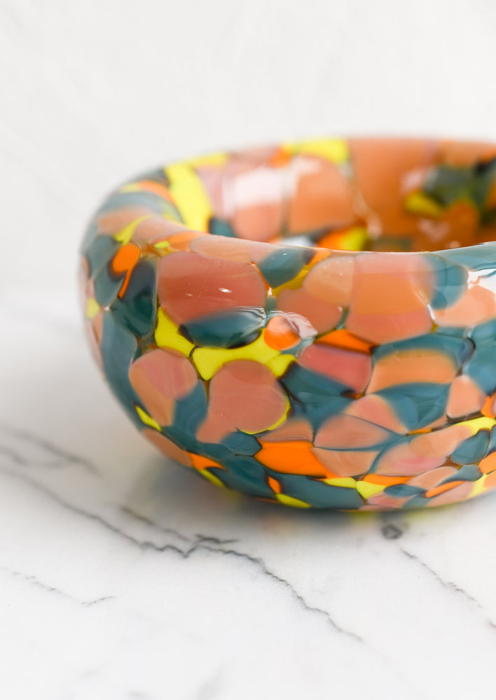 2: A speckled multicolor glass bowl in teal, peach, orange and yellow.