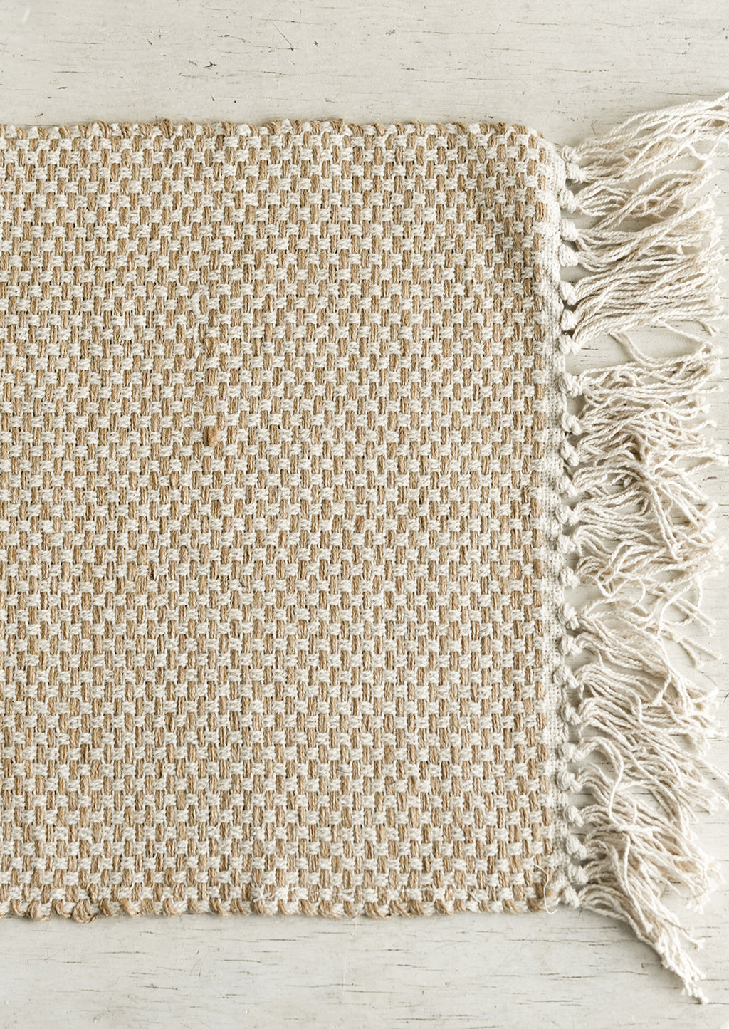 1: A natural jute-cotton placemat with cotton tassel trim.