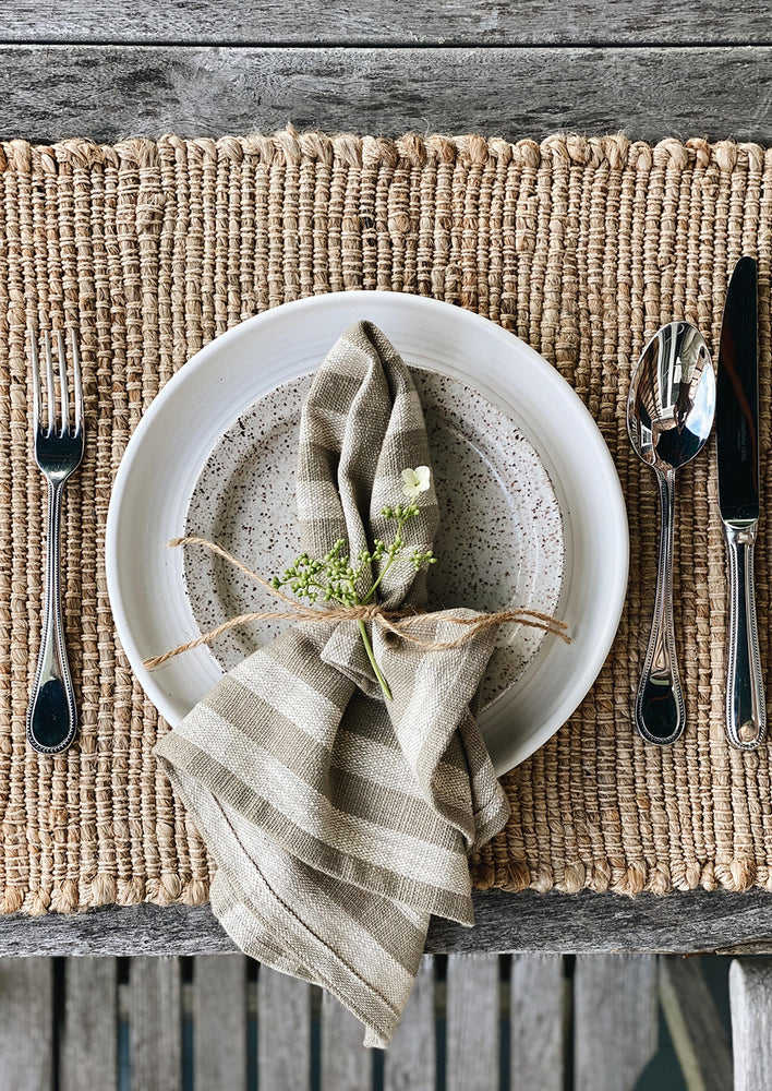 A jute placemat with tableware setting.