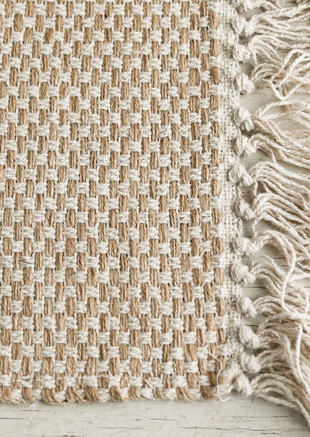 4: A natural jute-cotton placemat with cotton tassel trim.