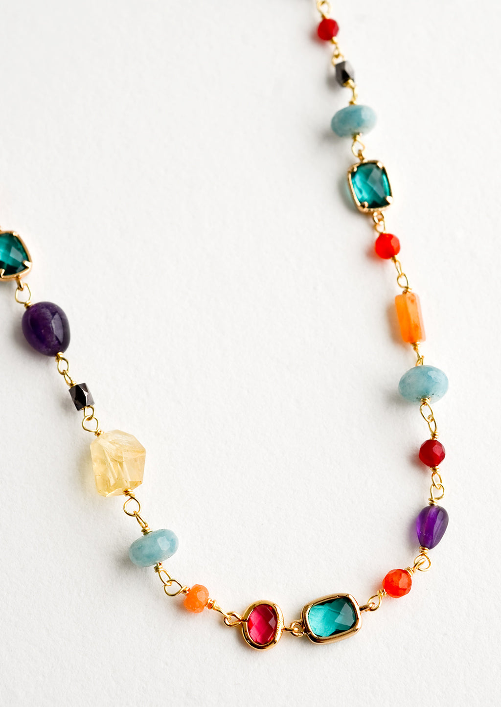 2: A necklace with individual, multicolor gemstone stations in a mix of shapes and sizes.