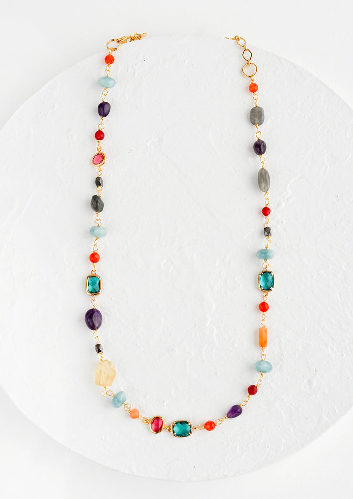 A necklace with individual, multicolor gemstone stations in a mix of shapes and sizes.