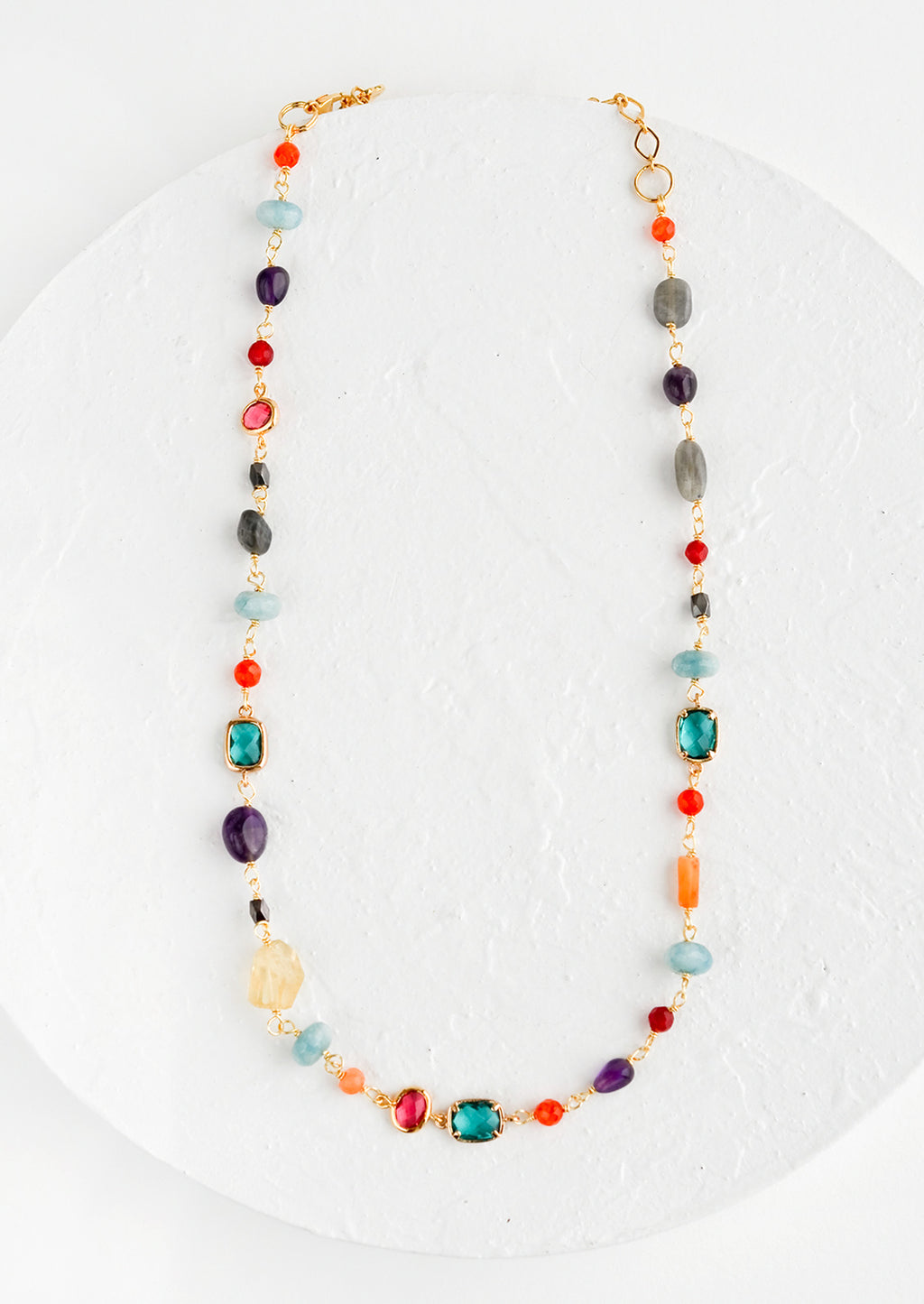 1: A necklace with individual, multicolor gemstone stations in a mix of shapes and sizes.