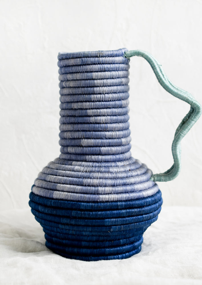 Lavender / Blue: A sculptural sweetgrass vase with wavy handle in blue multi.
