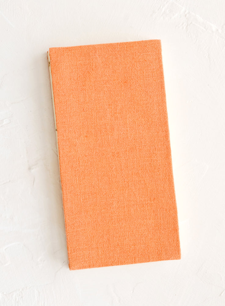 A cloth-covered notebook in naturally dyed peach hue.