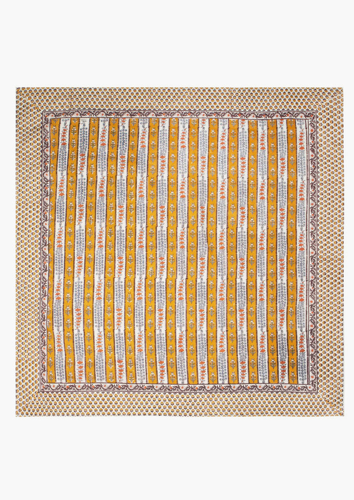 3: A stripe floral print tablecloth in marigold, purple and blue.