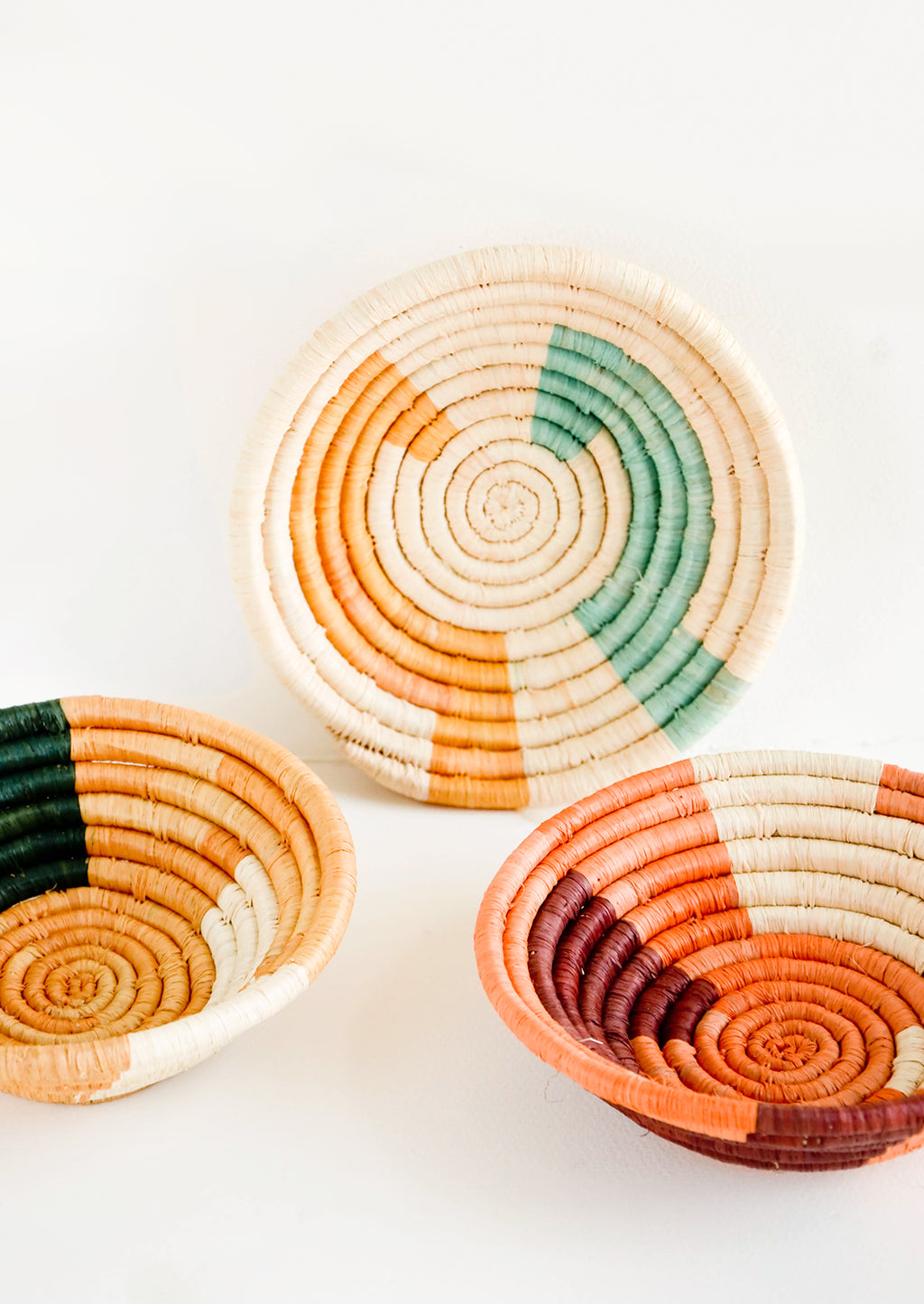 1: Assortment of three woven raffia bowls in a mix of color combos