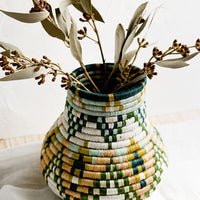 1: A woven sweetgrass vase holding dried eucalyptus.