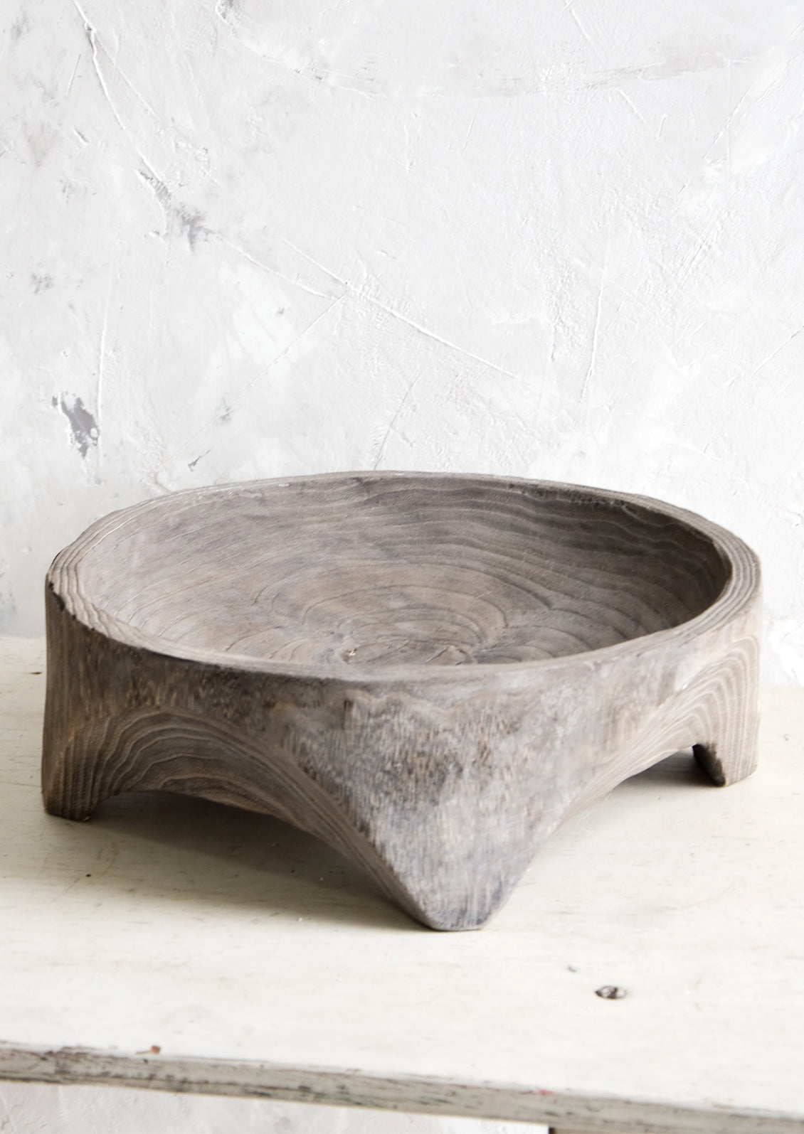 Round, primitive style shallow wooden display bowl with chunky footed base