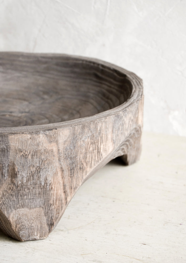 Chunky footed base on shallow wooden display bowl