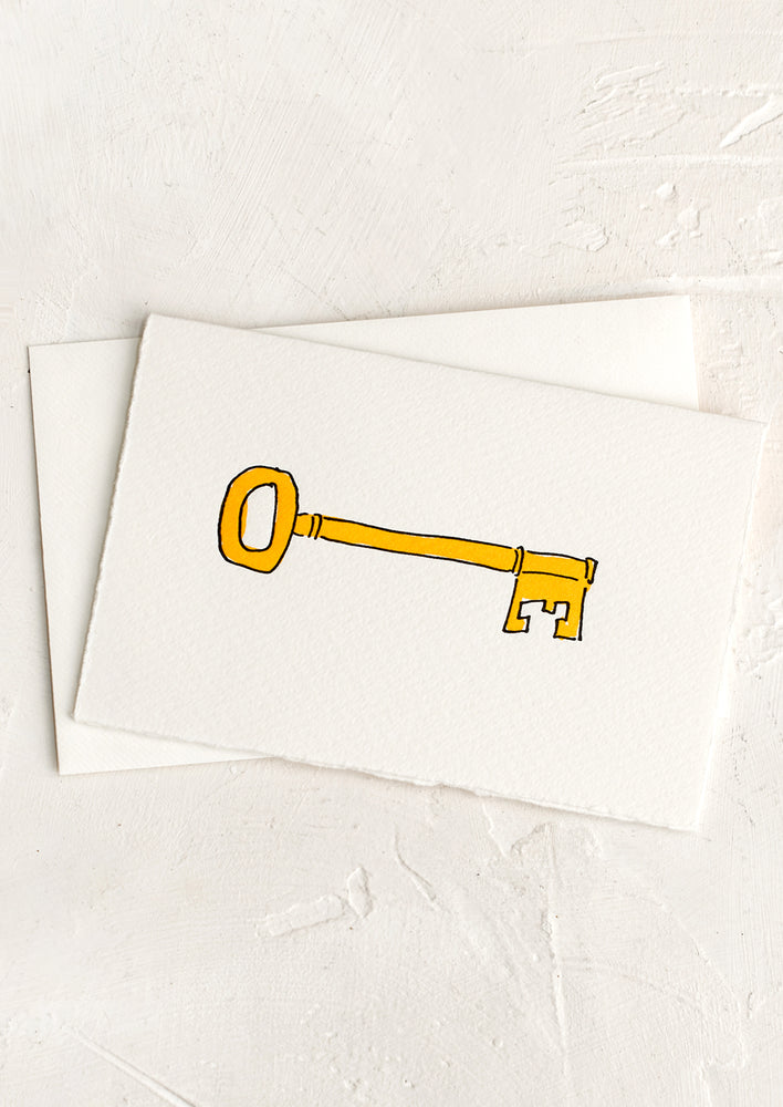A greeting card with drawing of hand painted yellow key.