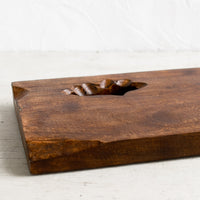 2: A rectangular wooden cutting board with knot cutout detail.