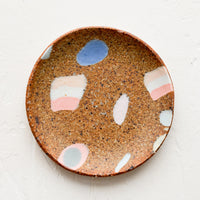 1: A round ceramic trinket dish with various inlay shapes.