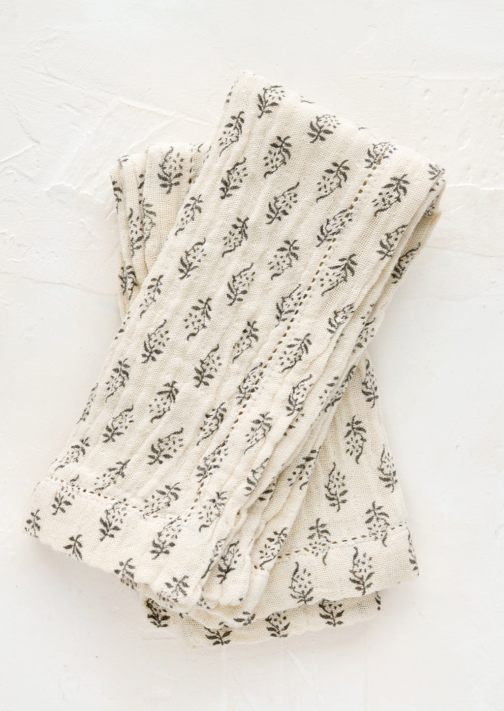 1: A pair of undyed cotton gauze napkins with grey floral motif and hemstitch detailing. 