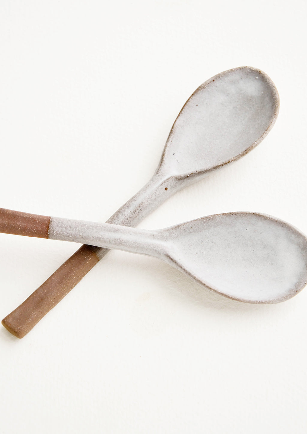 1: Ceramic spoons in earthy brown clay dipped in white glaze