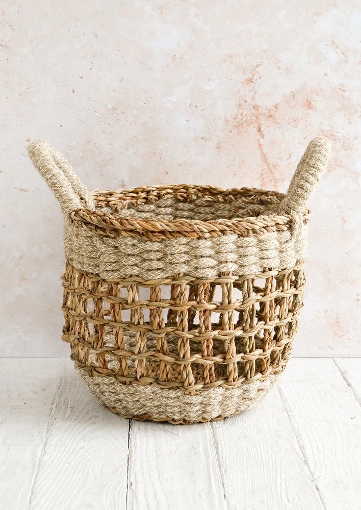 Small [$45.99]: A small open-top round storage basket made from seagrass with braided jute, featuring two handles at top.