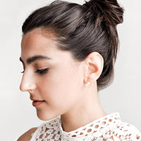 3: Model shot showing woman wearing earrings and white top.