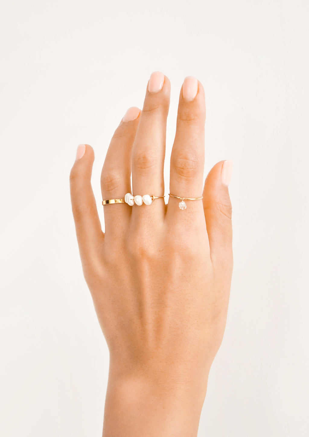 2: Model shot showing hand with several gold rings.