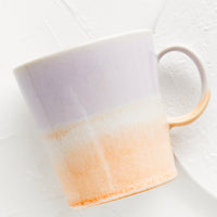 Lavender / Sherbet: A ceramic coffee mug with handle in light purple and pastel orange.