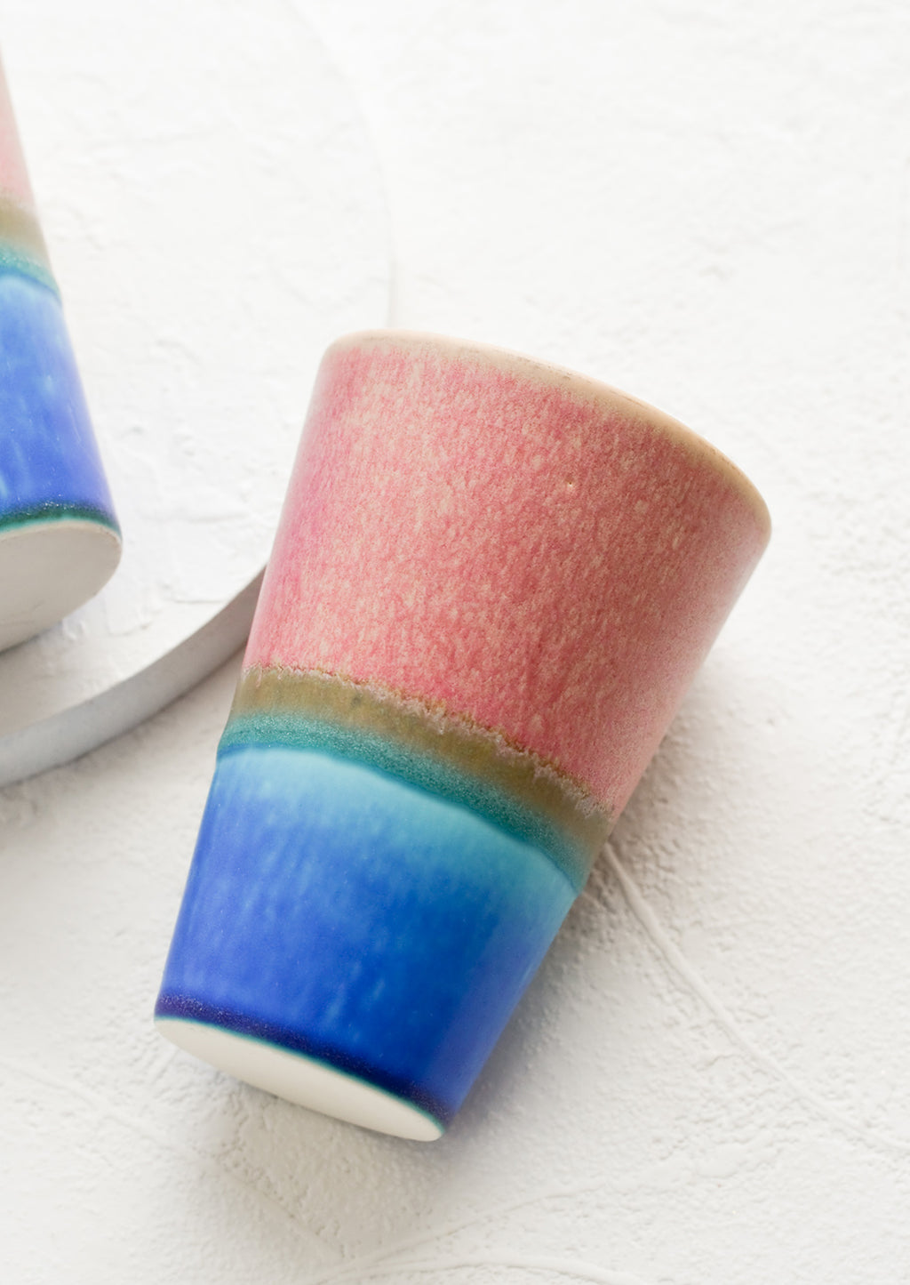 Pink / Bright Blue: A ceramic cup in pink and blue.