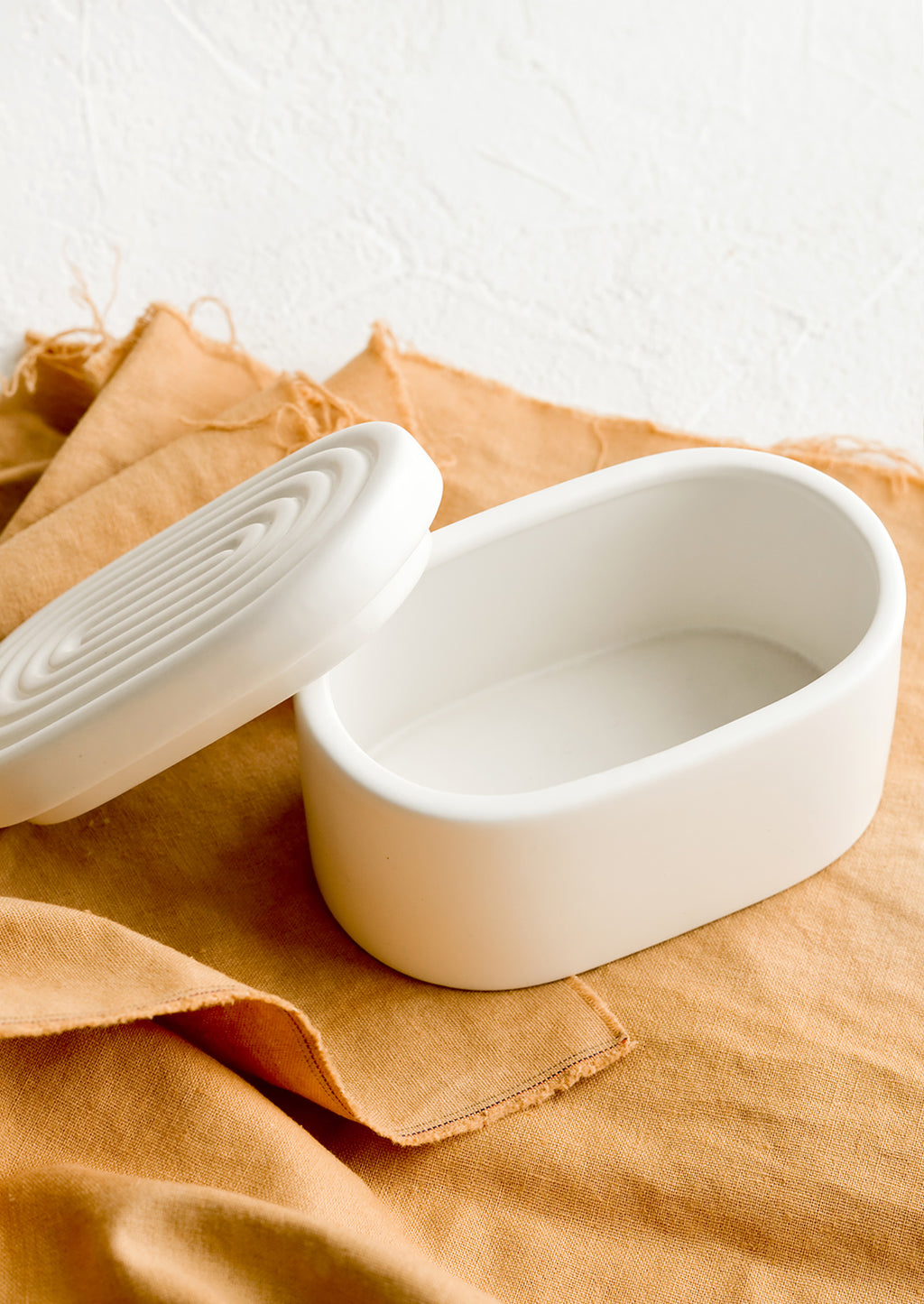 1: An oval-shaped white ceramic storage box.