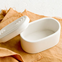 1: An oval-shaped white ceramic storage box.