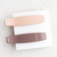 Nude / Mauve: A pair of hair clips with one nude and one mauve.