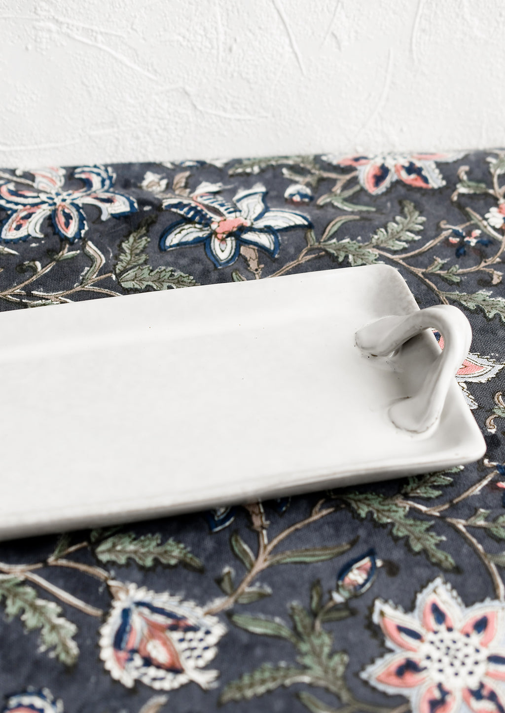 2: Long and skinny ceramic tray with side handle detail.