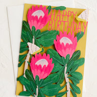 1: A birthday card with lasercut front panel with botanical protea design.