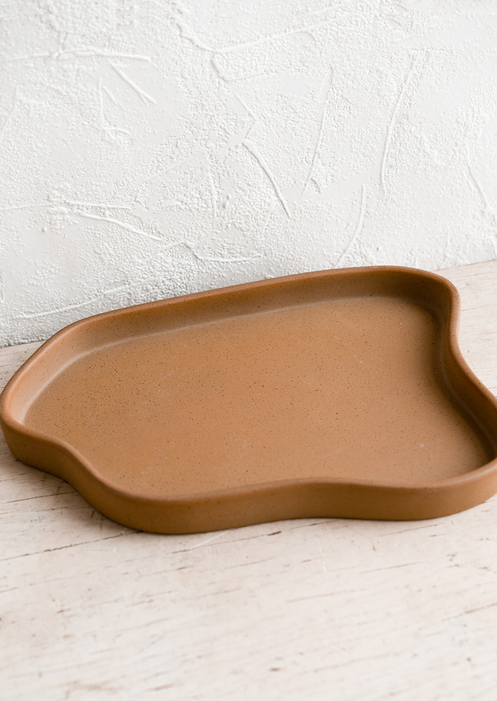 Large / Brown: An asymmetrical large ceramic tray in matte brown.
