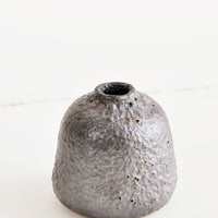 Small / Mercury: Heavily textured, short and wide ceramic bud vase in a metallic, crater-like dark grey glaze
