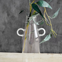 Large: A clear glass vase in bottle shape with curved white handles at sides.