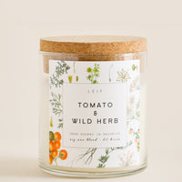 Tomato & Wild Herb: A glass candle with a cork lid and white botanical printed label reading "tomato and wild herb."