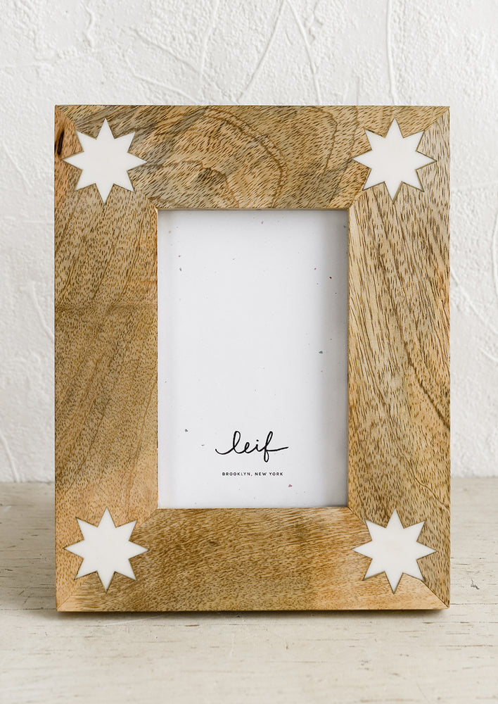 A mango wood picture frame with white 8-point stars at corners.