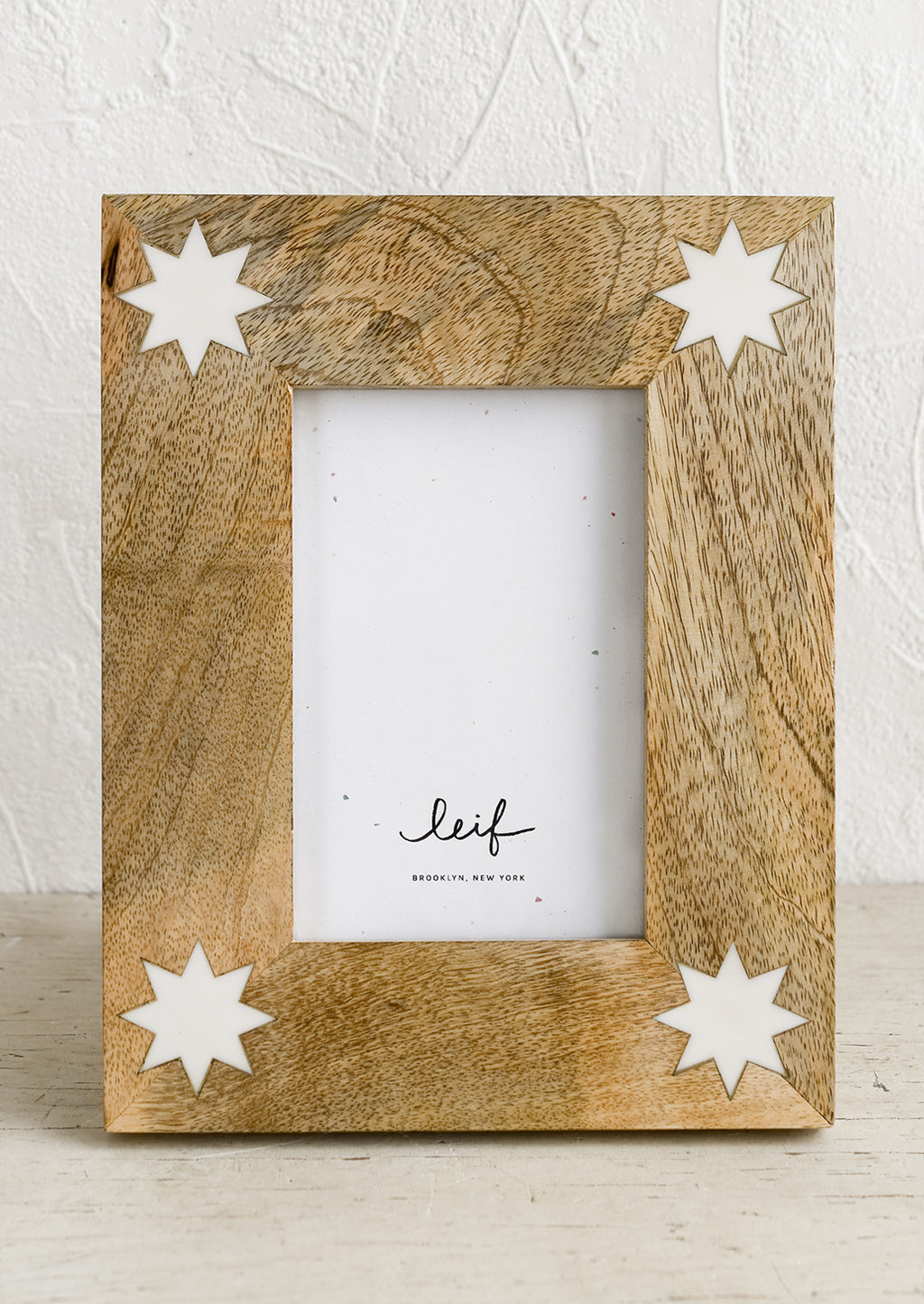 1: A mango wood picture frame with white 8-point stars at corners.