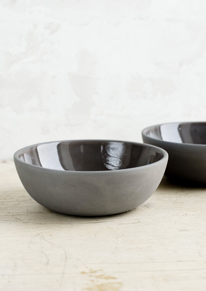 Matte porcelain bowls in charcoal hue with glossy interior.