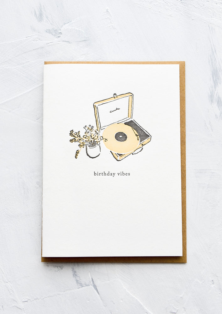 1: A letterpress printed greeting card with an image of a record player and flowers, text below image reads "birthday vibes".